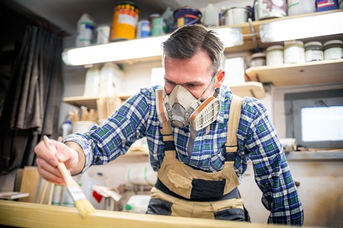 Man applying stain finish to wood