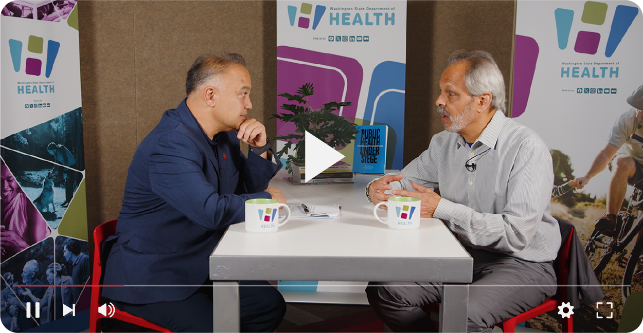 Dr. Umair Shah and Eduardo Sanchez talking at a table.