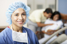 Image of a nurse with a couple holding a newborn in the background.