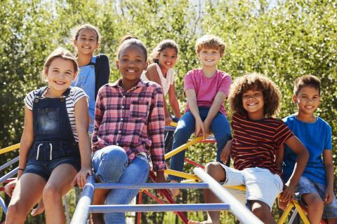 Pre-teens sitting on playground equipment