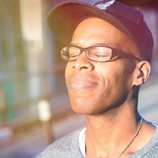 Man smiling with his eyes shut as the sun shines on his face