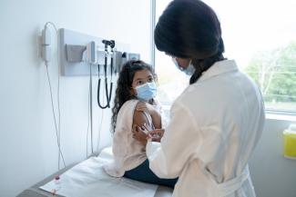 Health care worker giving a child a vaccination